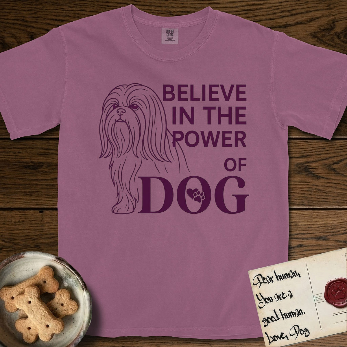 Believe in the Power of Dog Shih Tzu T-Shirt flat lay in Berry, featuring a clean single-color line drawing of a long-coated Shih Tzu beside the stacked words Believe in the Power of Dog with a paw print pressed into the O.