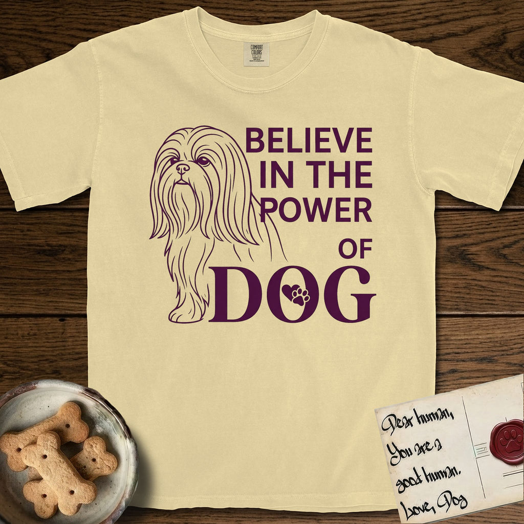 Believe in the Power of Dog Shih Tzu T-Shirt flat lay in Butter, featuring a clean single-color line drawing of a long-coated Shih Tzu beside the stacked words Believe in the Power of Dog with a paw print pressed into the O.