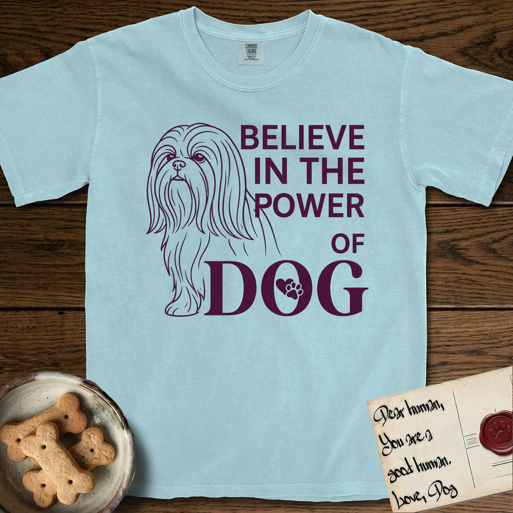 Believe in the Power of Dog Shih Tzu T-Shirt flat lay in Chambray, featuring a clean single-color line drawing of a long-coated Shih Tzu beside the stacked words Believe in the Power of Dog with a paw print pressed into the O.