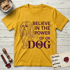 Believe in the Power of Dog Shih Tzu Line Drawing T-Shirt flat lay in Daisy, featuring a clean single-color line drawing of a long-coated Shih Tzu beside the stacked words Believe in the Power of Dog with a paw print pressed into the O.