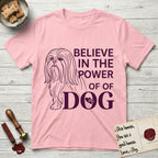 Believe in the Power of Dog Shih Tzu Line Drawing T-Shirt flat lay in Light Pink, featuring a clean single-color line drawing of a long-coated Shih Tzu beside the stacked words Believe in the Power of Dog with a paw print pressed into the O.