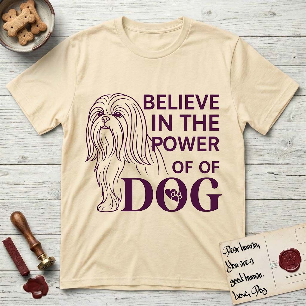 Believe in the Power of Dog Shih Tzu Line Drawing T-Shirt flat lay in Natural, featuring a clean single-color line drawing of a long-coated Shih Tzu beside the stacked words Believe in the Power of Dog with a paw print pressed into the O.