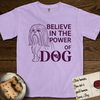 Believe in the Power of Dog Shih Tzu T-Shirt flat lay in Orchid, featuring a clean single-color line drawing of a long-coated Shih Tzu beside the stacked words Believe in the Power of Dog with a paw print pressed into the O.