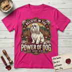 Believe in the Power of Dog Shih Tzu Throne T-Shirt flat lay in Heliconia, featuring an ornate dark badge with a Shih Tzu seated on a throne among chrysanthemums, lotus blossoms and mountain landscapes, and the words Grace, Wisdom, Devotion.