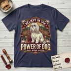 Believe in the Power of Dog Shih Tzu Throne T-Shirt flat lay in Navy, featuring an ornate dark badge with a Shih Tzu seated on a throne among chrysanthemums, lotus blossoms and mountain landscapes, and the words Grace, Wisdom, Devotion.