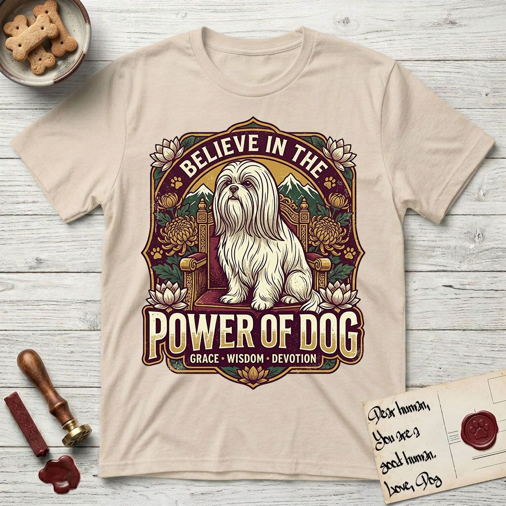 Believe in the Power of Dog Shih Tzu Throne T-Shirt flat lay in Sand, featuring an ornate dark badge with a Shih Tzu seated on a throne among chrysanthemums, lotus blossoms and mountain landscapes, and the words Grace, Wisdom, Devotion.