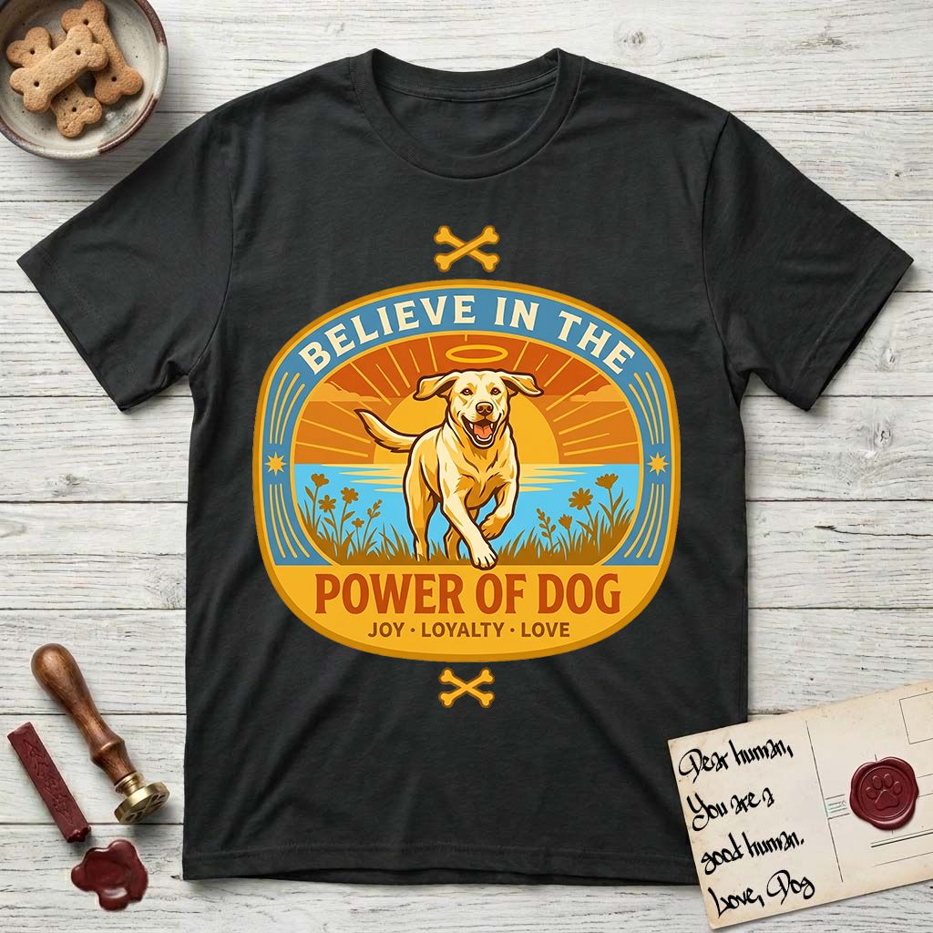 Believe in the Power of Dog Yellow Lab T-Shirt flat lay in Black, featuring a vintage oval badge with a haloed Yellow Lab running through a field of wildflowers and the words Joy, Loyalty, Love.