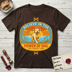 Believe in the Power of Dog Yellow Lab T-Shirt flat lay in Dark Chocolate, featuring a vintage oval badge with a haloed Yellow Lab running through a field of wildflowers and the words Joy, Loyalty, Love.