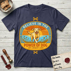 Believe in the Power of Dog Yellow Lab T-Shirt flat lay in Navy, featuring a vintage oval badge with a haloed Yellow Lab running through a field of wildflowers and the words Joy, Loyalty, Love.