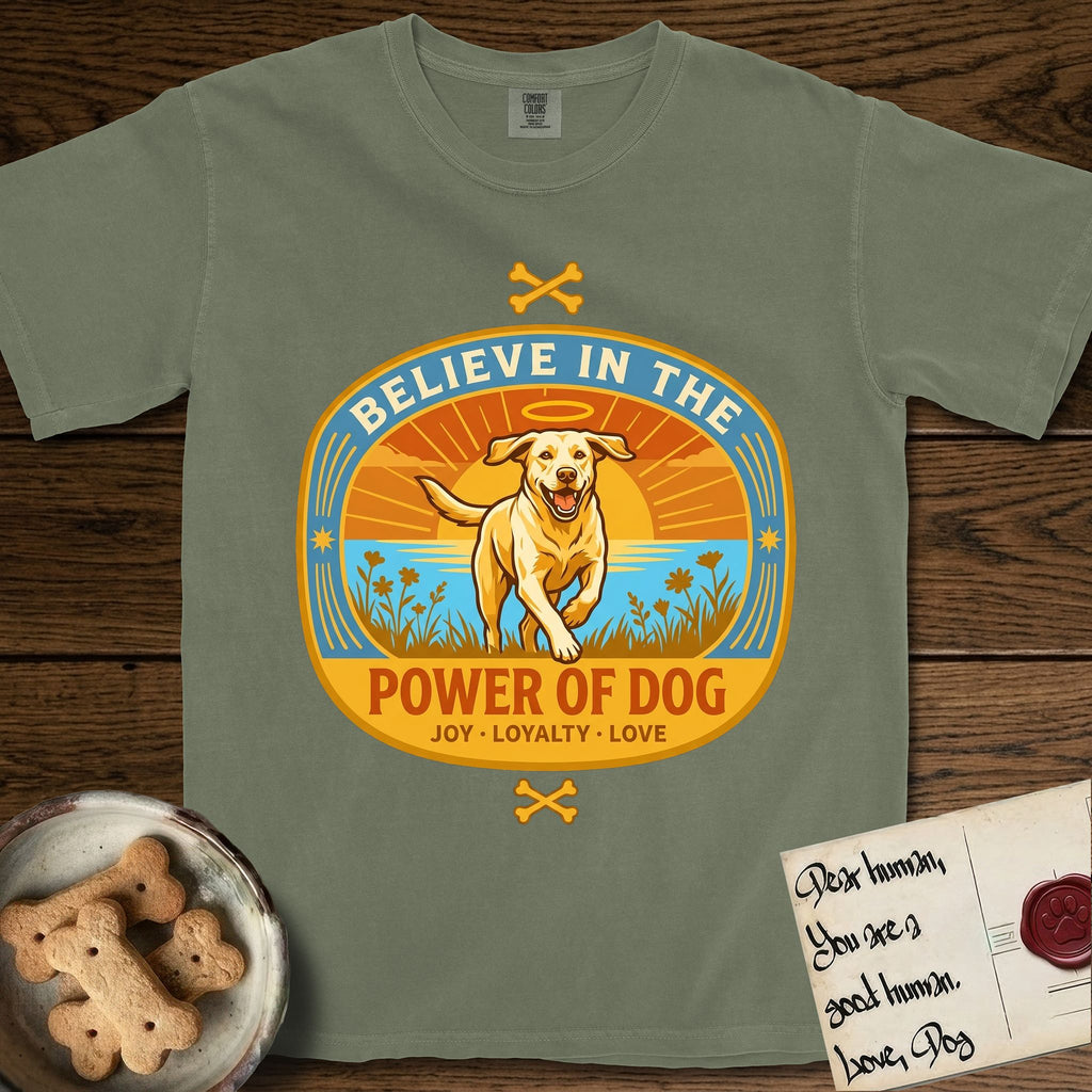 Believe in the Power of Dog Yellow Lab T-Shirt flat lay in Sage, featuring a vintage oval badge with a haloed Yellow Lab running through a field of wildflowers and the words Joy, Loyalty, Love.
