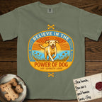 Believe in the Power of Dog Yellow Lab T-Shirt flat lay in Sage, featuring a vintage oval badge with a haloed Yellow Lab running through a field of wildflowers and the words Joy, Loyalty, Love.