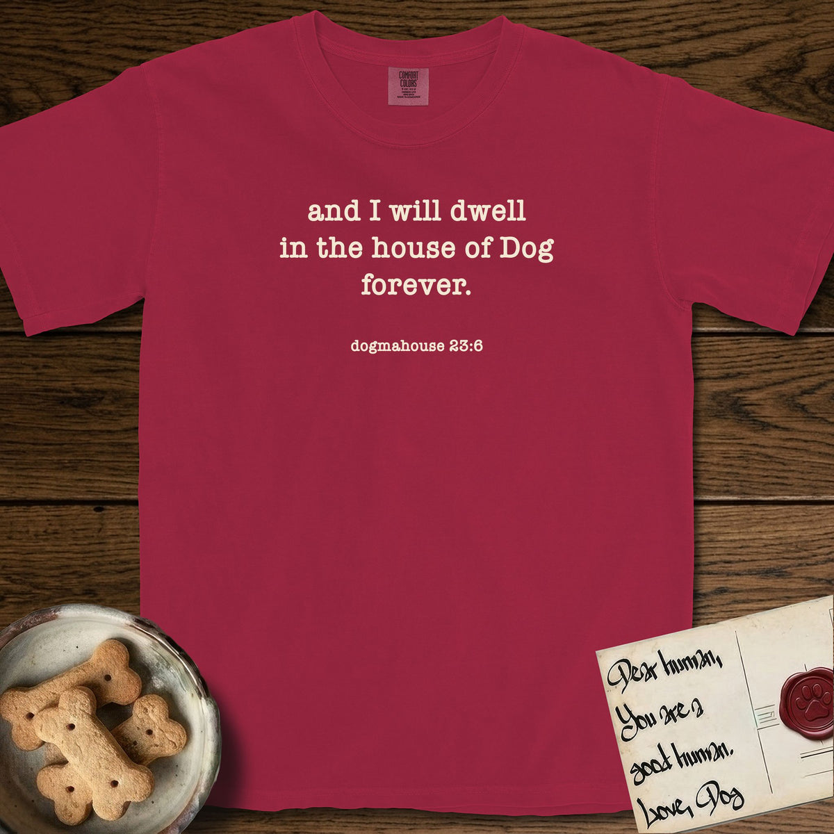 And I Will Dwell T-Shirt flat lay in Chili, featuring Small centered typewriter-type text reading and I will dwell in the house of Dog forever, with the citation dogmahouse 23:6 beneath it.