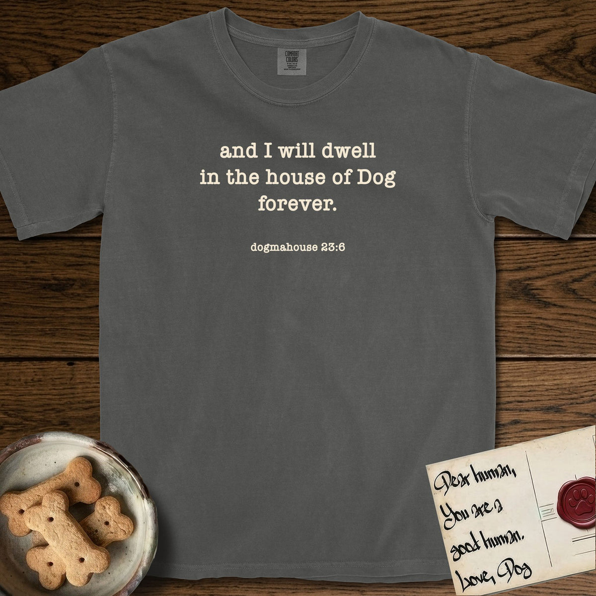 And I Will Dwell T-Shirt flat lay in Pepper, featuring Small centered typewriter-type text reading and I will dwell in the house of Dog forever, with the citation dogmahouse 23:6 beneath it.