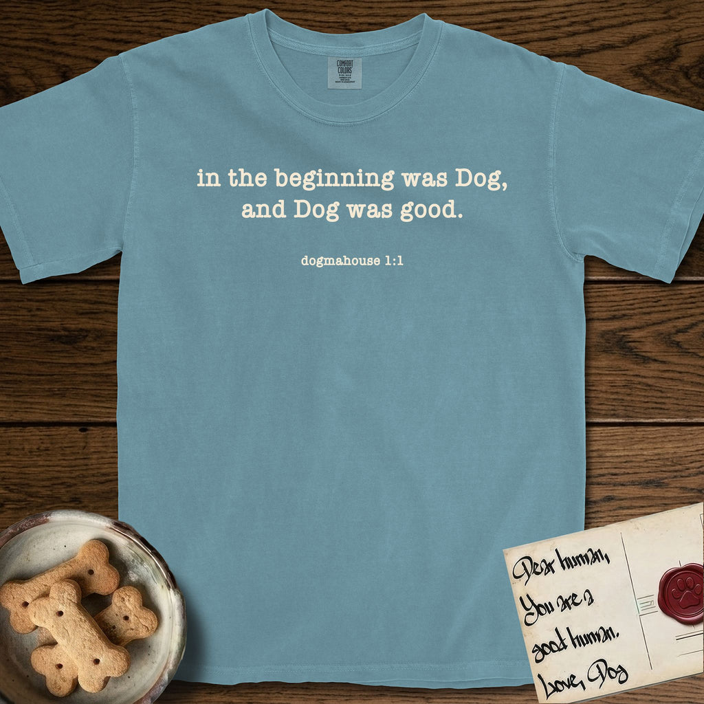 In the Beginning T-Shirt flat lay in Ice Blue, featuring Small centered typewriter-type text reading in the beginning was Dog, and Dog was good, with the citation dogmahouse 1:1 beneath it.