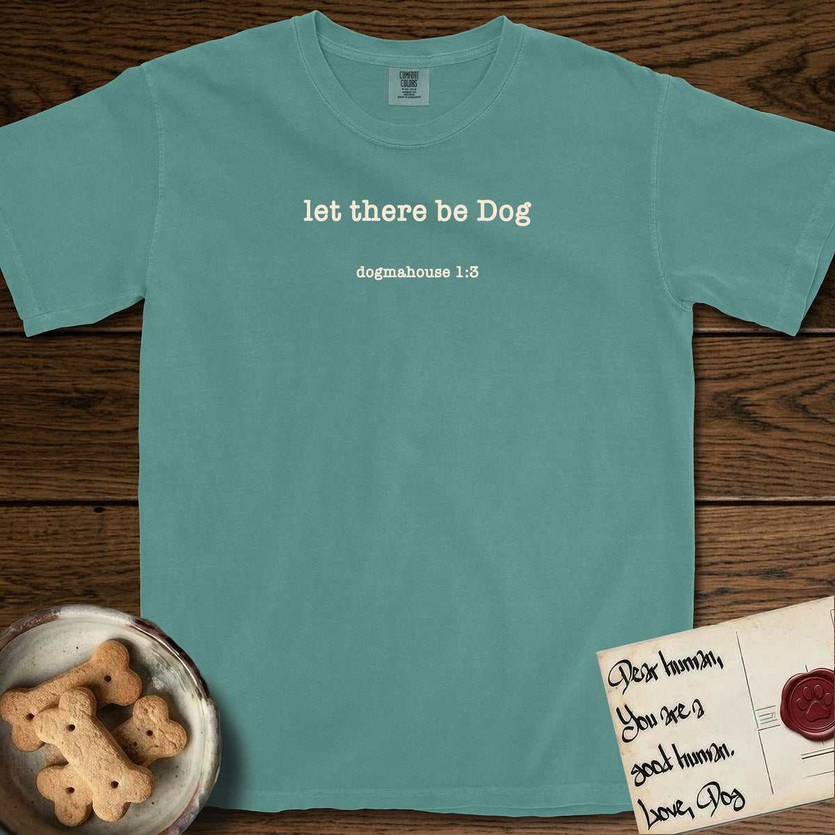 Let There Be Dog T-Shirt flat lay in Blue Spruce, featuring Small centered typewriter-type text reading let there be Dog, with the citation dogmahouse 1:3 beneath it.