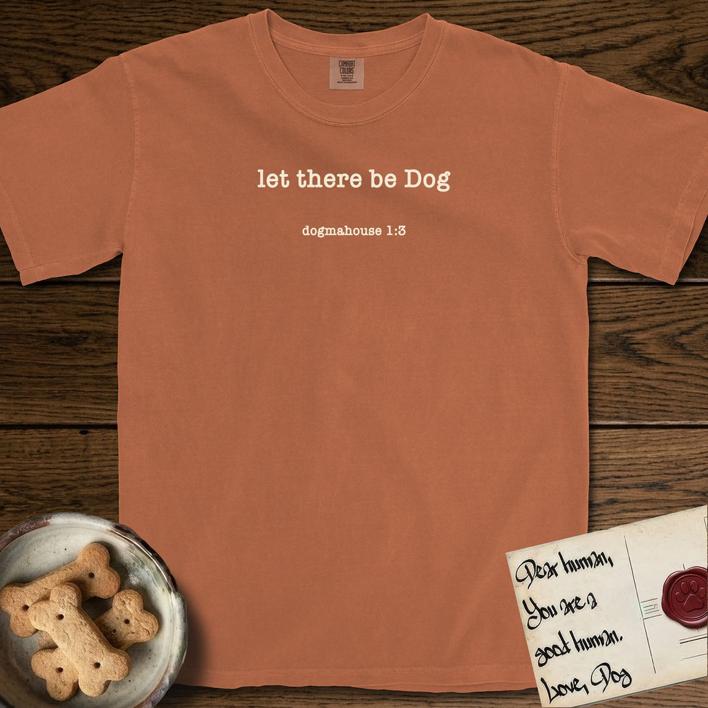 Let There Be Dog T-Shirt flat lay in Yam, featuring Small centered typewriter-type text reading let there be Dog, with the citation dogmahouse 1:3 beneath it.