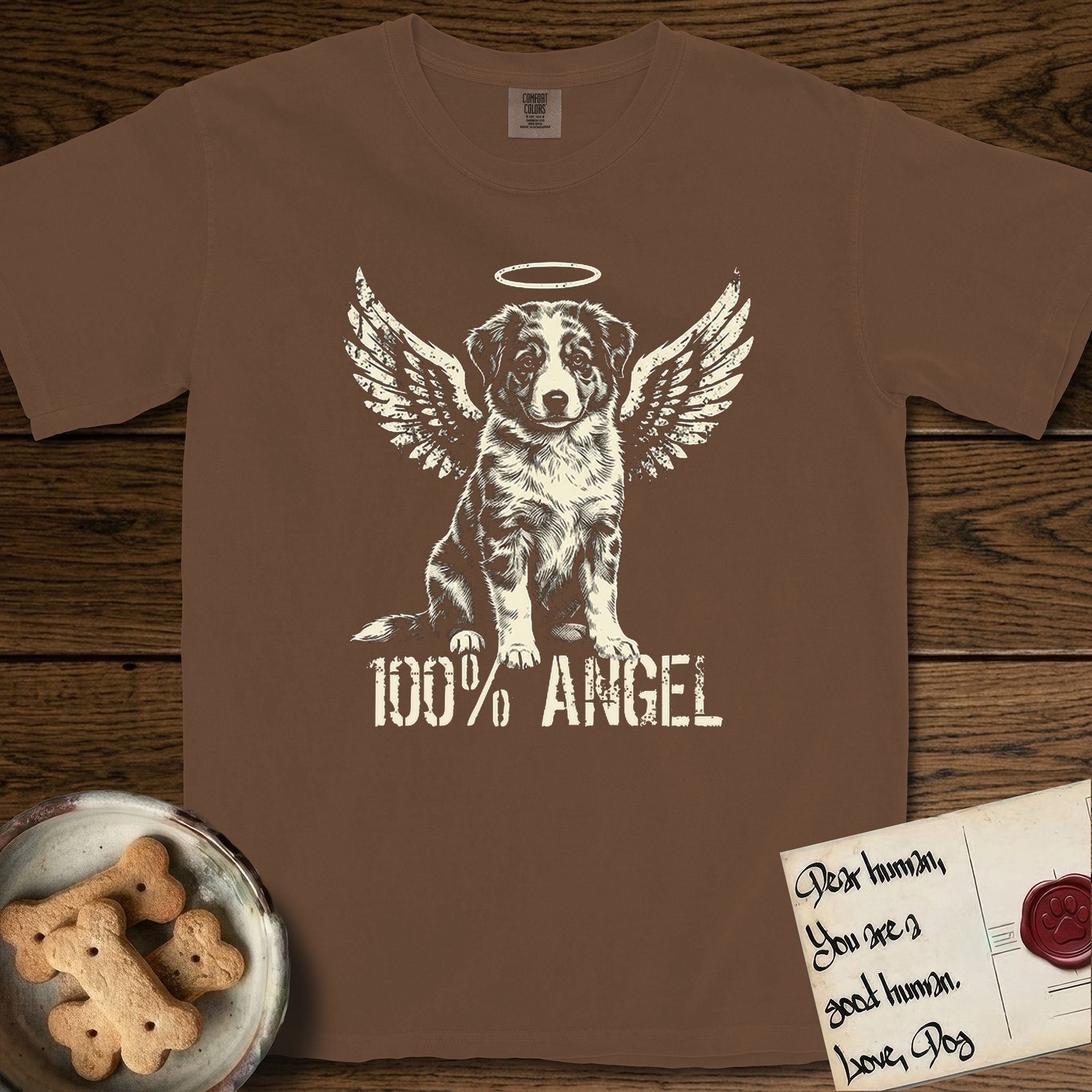 Australian Shepherd T-Shirt flat lay in Espresso, featuring Distressed cream one-color screen-print of a blue merle Australian Shepherd puppy as an angel, wings raised and a halo above, with 100% ANGEL lettering across the bottom.