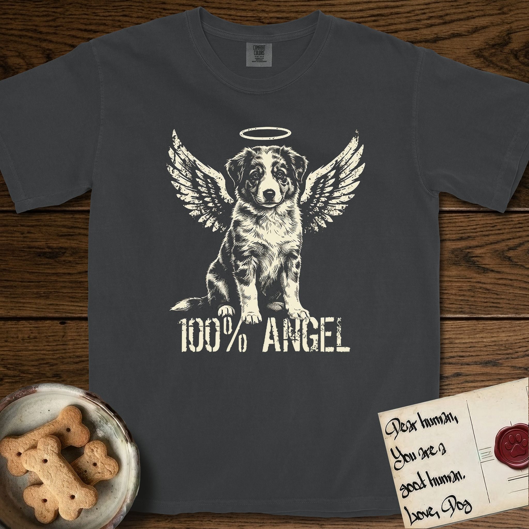 Australian Shepherd T-Shirt flat lay in Graphite, featuring Distressed cream one-color screen-print of a blue merle Australian Shepherd puppy as an angel, wings raised and a halo above, with 100% ANGEL lettering across the bottom.