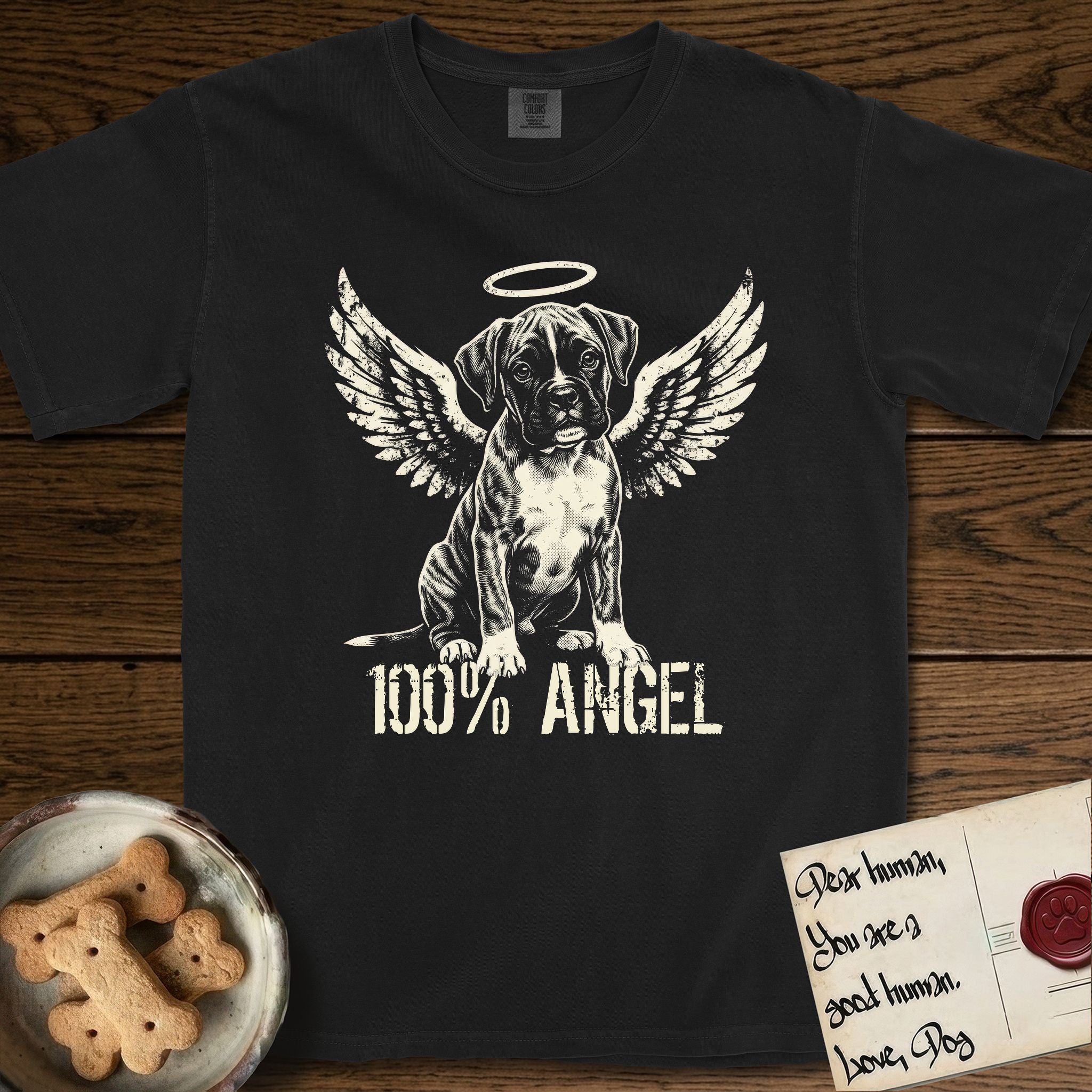 Boxer T-Shirt flat lay in Black, featuring Distressed cream one-color screen-print of a Boxer puppy as an angel, wrinkly face with a slight head tilt, wings spread and a halo above, with 100% ANGEL lettering across the bottom.