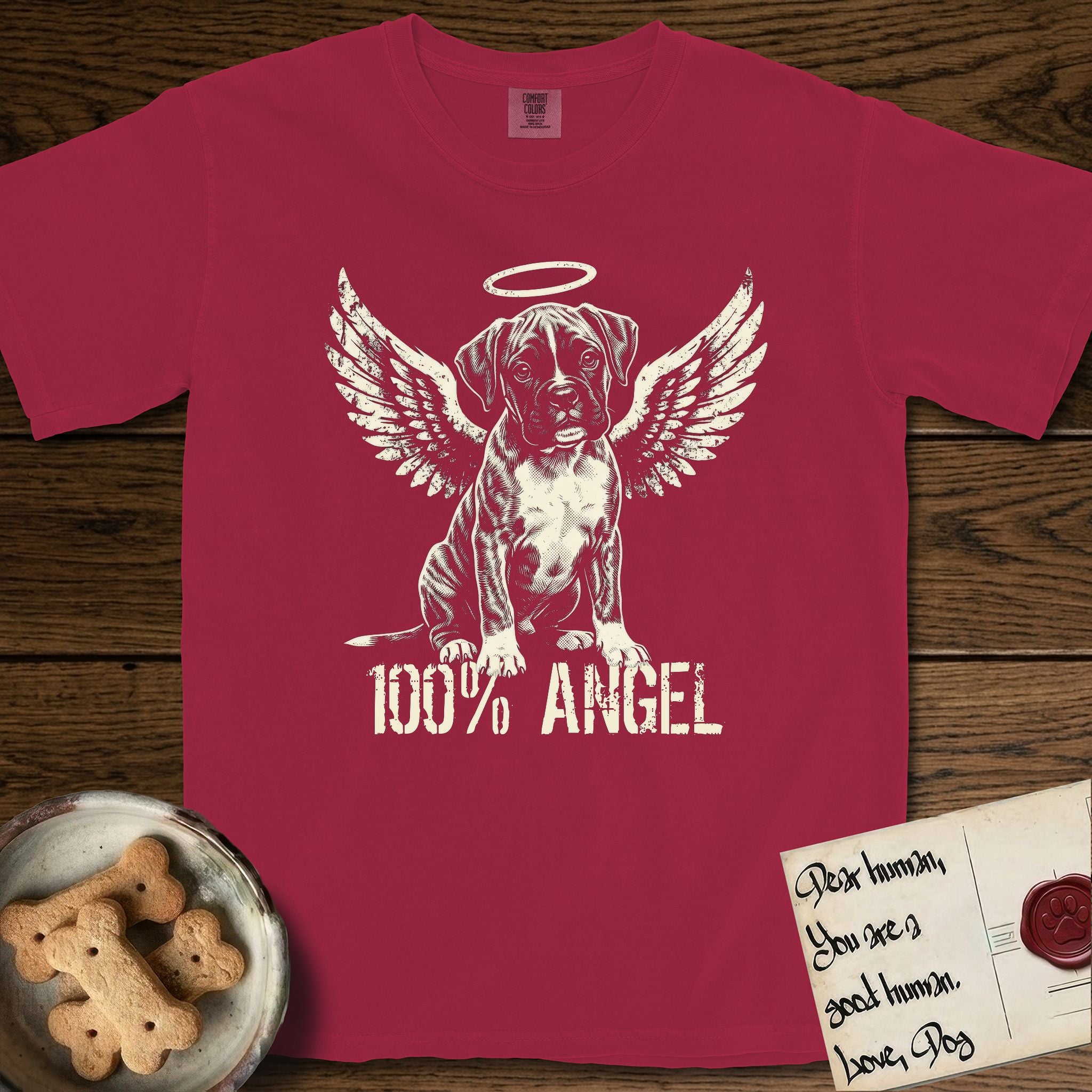 Boxer T-Shirt flat lay in Chili, featuring Distressed cream one-color screen-print of a Boxer puppy as an angel, wrinkly face with a slight head tilt, wings spread and a halo above, with 100% ANGEL lettering across the bottom.