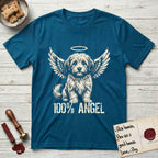Coton de Tulear T-Shirt flat lay in Antique Sapphire, featuring Distressed cream one-color screen-print of a fluffy white Coton de Tulear puppy as an angel, plumed tail curled beside him, wings spread and a halo above, with 100% ANGEL lettering across the bottom.