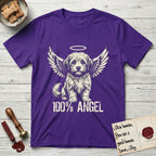 Coton de Tulear T-Shirt flat lay in Purple, featuring Distressed cream one-color screen-print of a fluffy white Coton de Tulear puppy as an angel, plumed tail curled beside him, wings spread and a halo above, with 100% ANGEL lettering across the bottom.
