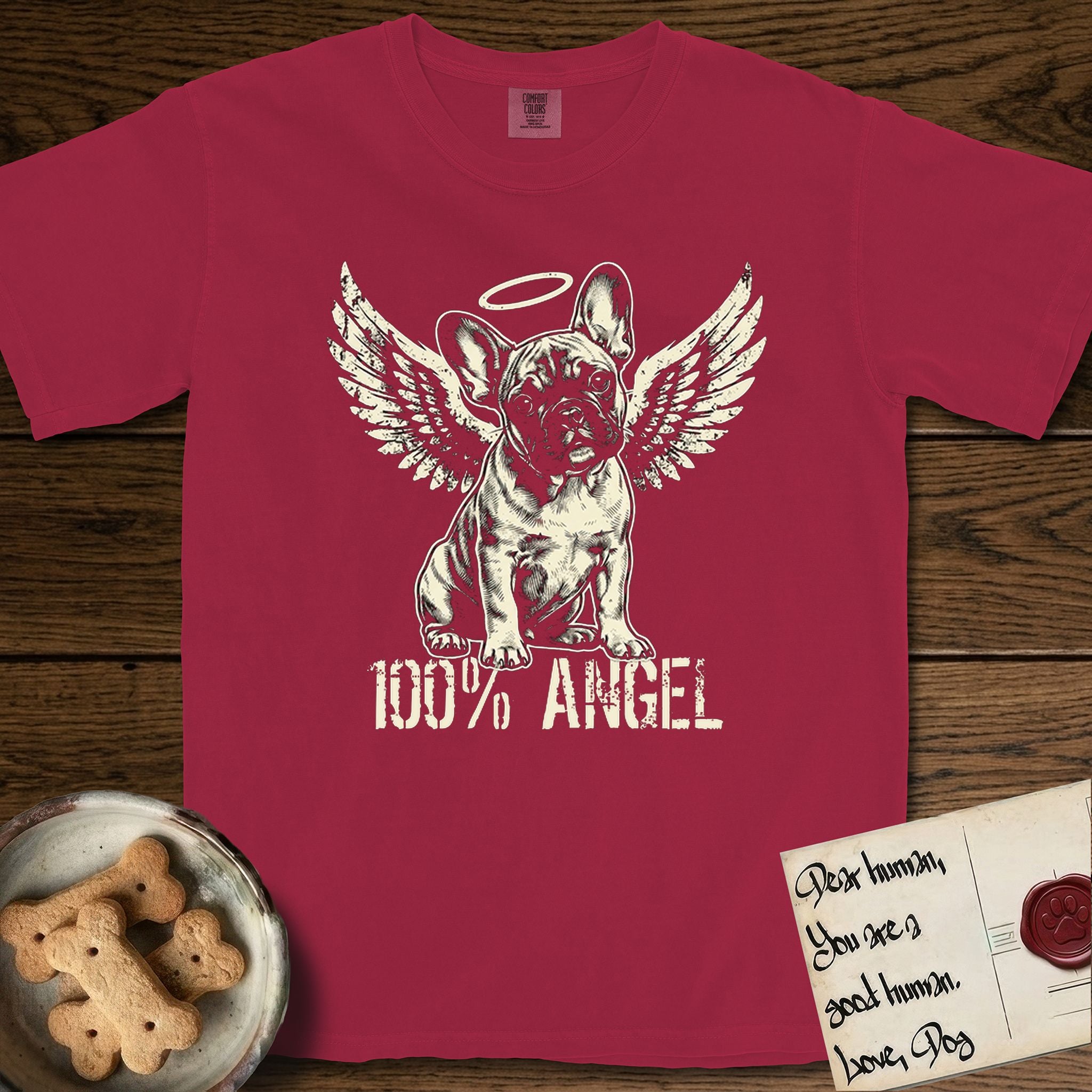 French Bulldog T-Shirt flat lay in Chili, featuring Distressed cream one-color screen-print of a French Bulldog puppy as an angel, head cocked to one side, wings spread and a halo above, with 100% ANGEL lettering across the bottom.