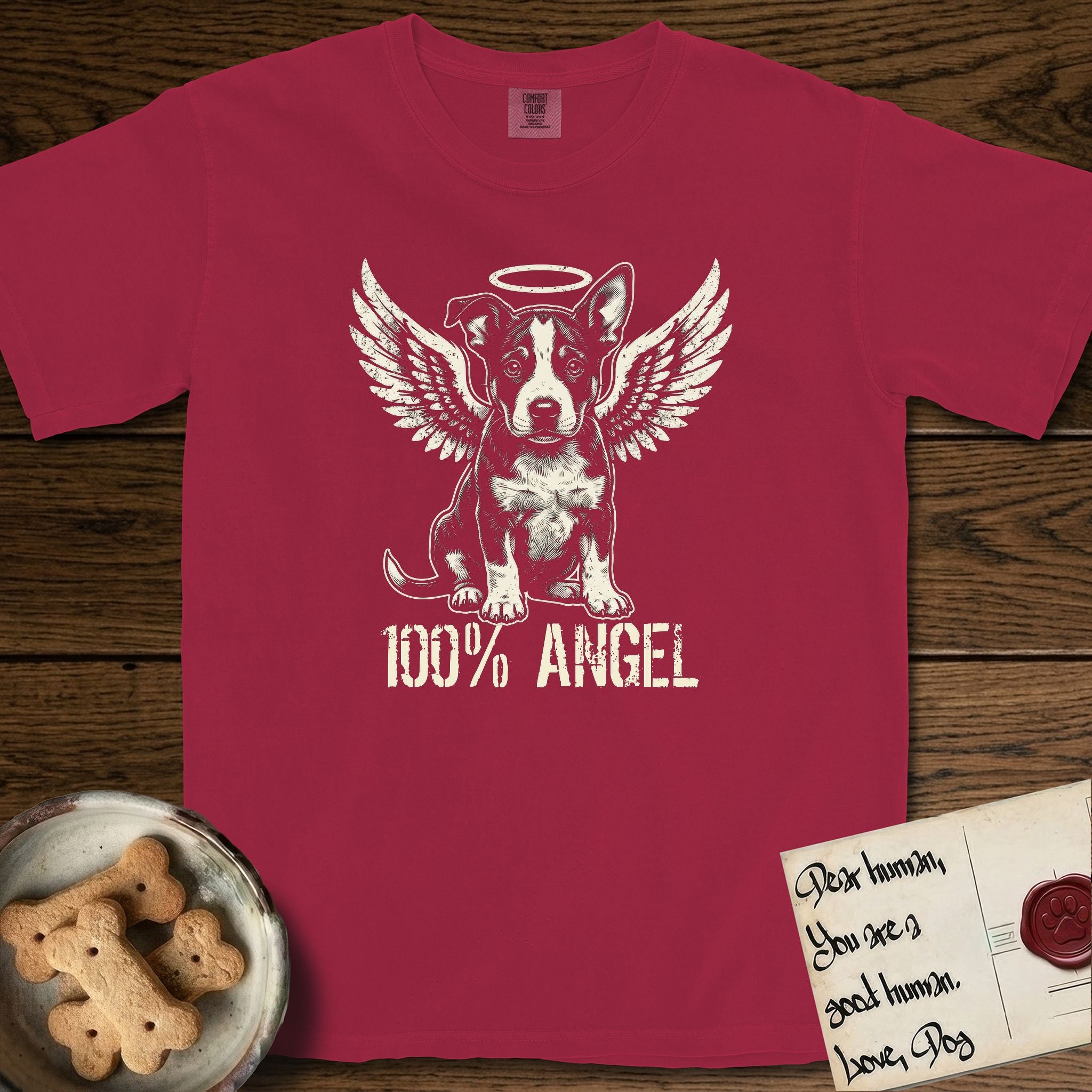 Lobo T-Shirt flat lay in Chili, featuring Distressed cream one-color screen-print of a black-and-white Australian Cattle Dog and Pitbull mix puppy as an angel, big upright ears with one tip folded, wings spread and a halo above, with 100% ANGEL lettering across the bottom.