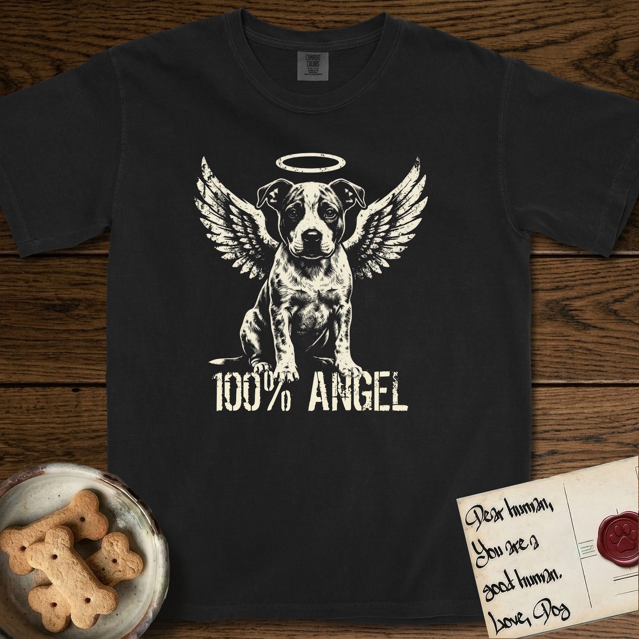 Pitbull T-Shirt flat lay in Black, featuring Distressed cream one-color screen-print of a Pitbull puppy as an angel, feathered wings spread and a halo above, sitting front-on, with 100% ANGEL lettering across the bottom.