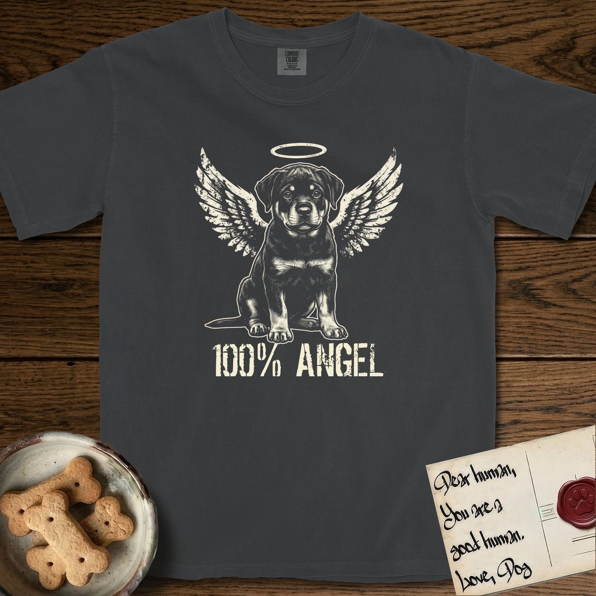 Rottweiler T-Shirt flat lay in Graphite, featuring Distressed cream one-color screen-print of a Rottweiler puppy as an angel, sitting square and sturdy, wings spread and a halo above, with 100% ANGEL lettering across the bottom.