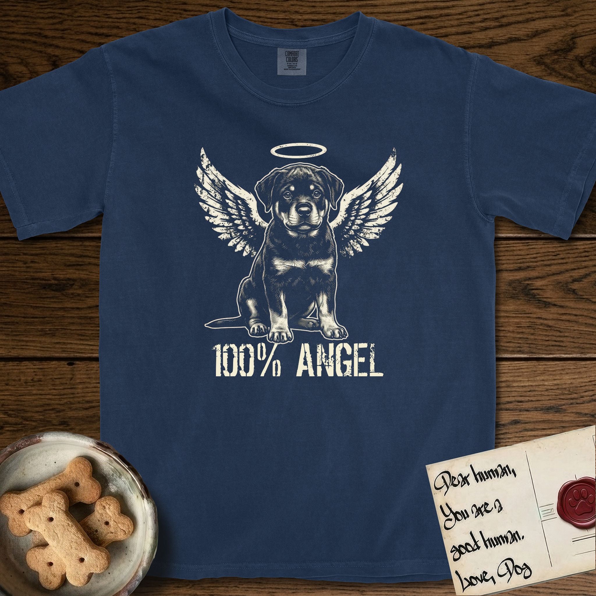 Rottweiler T-Shirt flat lay in True Navy, featuring Distressed cream one-color screen-print of a Rottweiler puppy as an angel, sitting square and sturdy, wings spread and a halo above, with 100% ANGEL lettering across the bottom.
