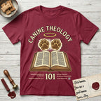 Canine Theology 101 T-Shirt flat lay in Cardinal Red, featuring a cream badge with an open book and two glowing paw prints rising above it, ringed by a circular halo.