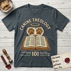 Canine Theology 101 T-Shirt flat lay in Dark Heather Grey, featuring a cream badge with an open book and two glowing paw prints rising above it, ringed by a circular halo.