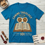 Canine Theology 101 T-Shirt flat lay in Sapphire, featuring a cream badge with an open book and two glowing paw prints rising above it, ringed by a circular halo.