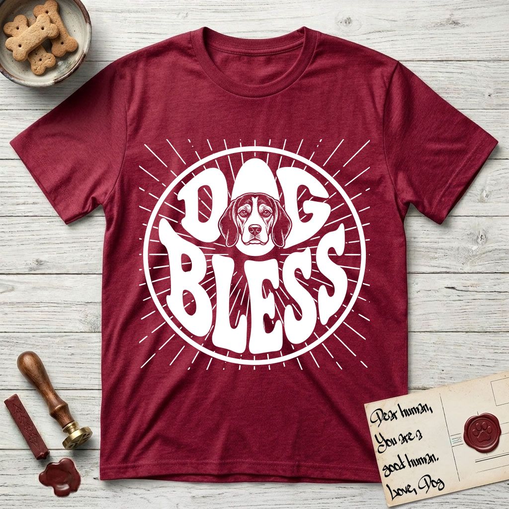 Dog Bless Beagle T-Shirt flat lay in Antique Cherry Red, featuring Retro bubble-letter badge reading DOG BLESS with a gentle Beagle face framed in the letter O, hand-drawn sunburst rays radiating outward.