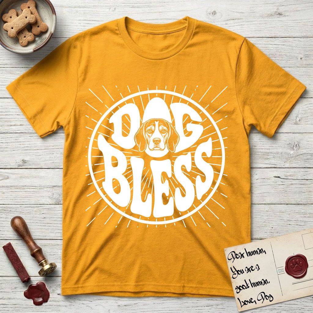 Dog Bless Beagle T-Shirt flat lay in Gold, featuring Retro bubble-letter badge reading DOG BLESS with a gentle Beagle face framed in the letter O, hand-drawn sunburst rays radiating outward.