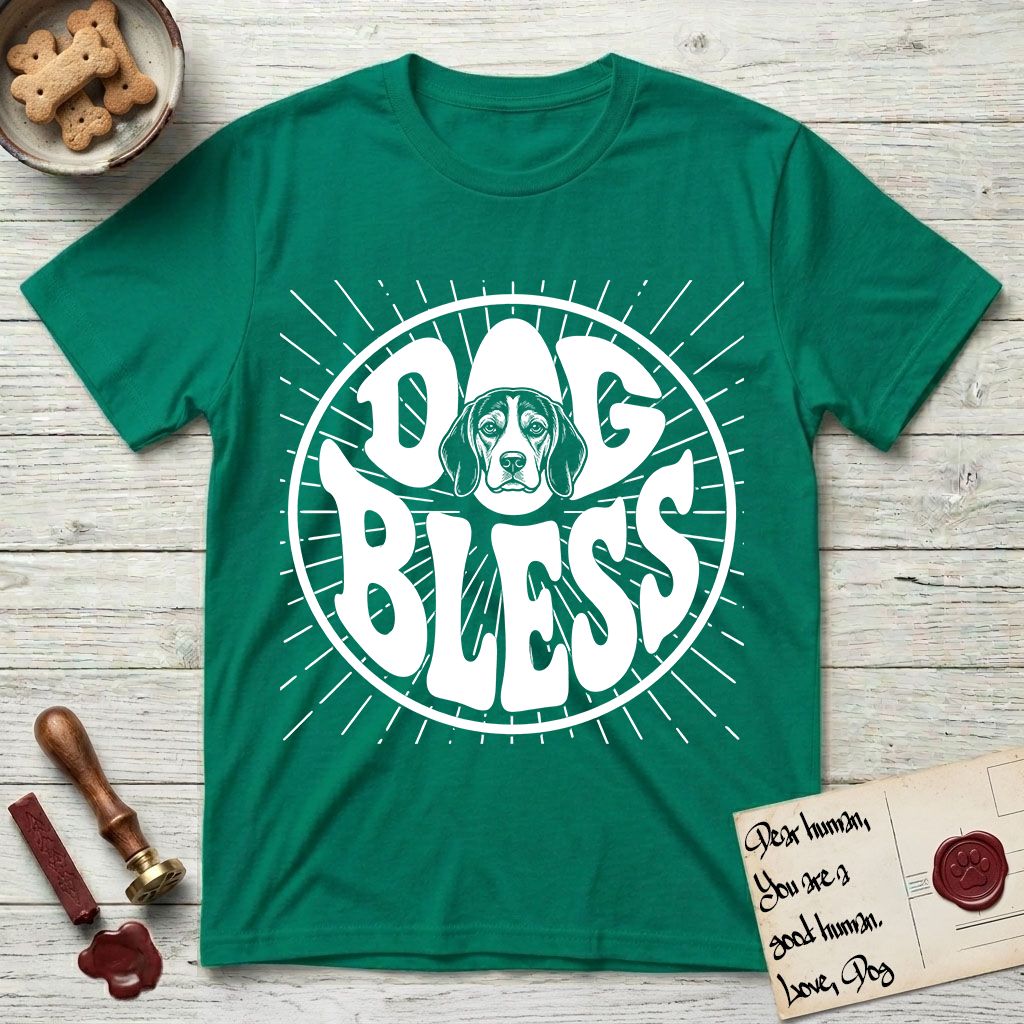 Dog Bless Beagle T-Shirt flat lay in Kelly Green, featuring Retro bubble-letter badge reading DOG BLESS with a gentle Beagle face framed in the letter O, hand-drawn sunburst rays radiating outward.