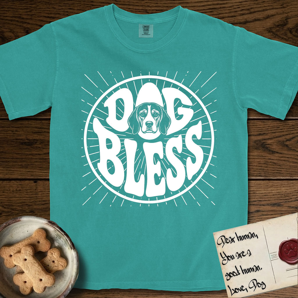 Dog Bless Beagle T-Shirt flat lay in Seafoam, featuring Retro bubble-letter badge reading DOG BLESS with a gentle Beagle face framed in the letter O, hand-drawn sunburst rays radiating outward.