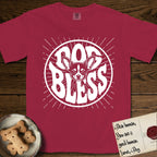 Dog Bless Chihuahua T-Shirt flat lay in Chili, featuring Retro bubble-letter badge reading DOG BLESS with a wide-eyed Chihuahua face framed in the letter O, oversized ears reaching past the letter, hand-drawn sunburst rays radiating outward.