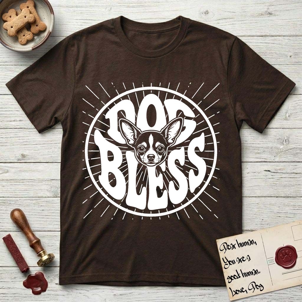 Dog Bless Chihuahua T-Shirt flat lay in Dark Chocolate, featuring Retro bubble-letter badge reading DOG BLESS with a wide-eyed Chihuahua face framed in the letter O, oversized ears reaching past the letter, hand-drawn sunburst rays radiating outward.