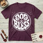 Dog Bless Chihuahua T-Shirt flat lay in Maroon, featuring Retro bubble-letter badge reading DOG BLESS with a wide-eyed Chihuahua face framed in the letter O, oversized ears reaching past the letter, hand-drawn sunburst rays radiating outward.