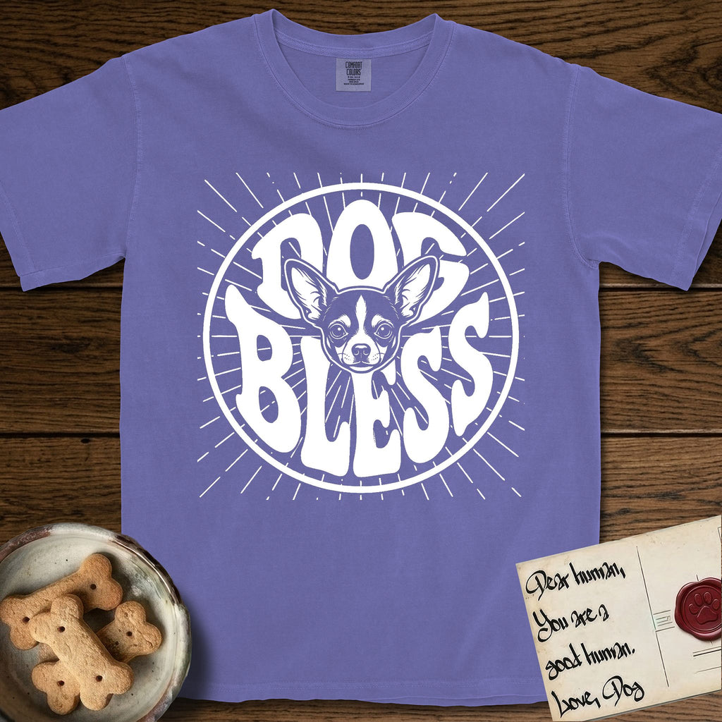 Dog Bless Chihuahua T-Shirt flat lay in Violet, featuring Retro bubble-letter badge reading DOG BLESS with a wide-eyed Chihuahua face framed in the letter O, oversized ears reaching past the letter, hand-drawn sunburst rays radiating outward.