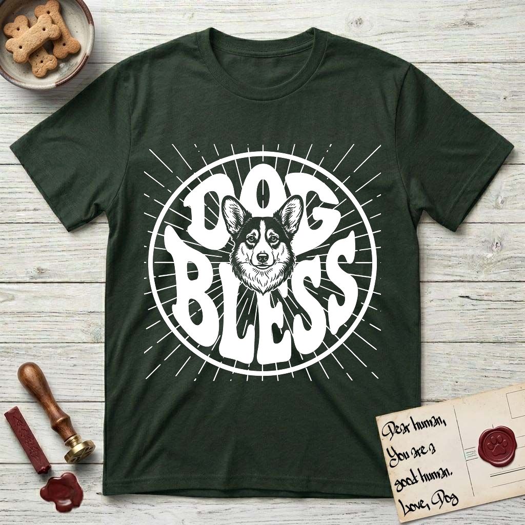 Dog Bless Corgi T-Shirt flat lay in Forest Green, featuring Retro bubble-letter badge reading DOG BLESS with a smiling Corgi face framed in the letter O, chest fluff spilling below the letter, hand-drawn sunburst rays radiating outward.