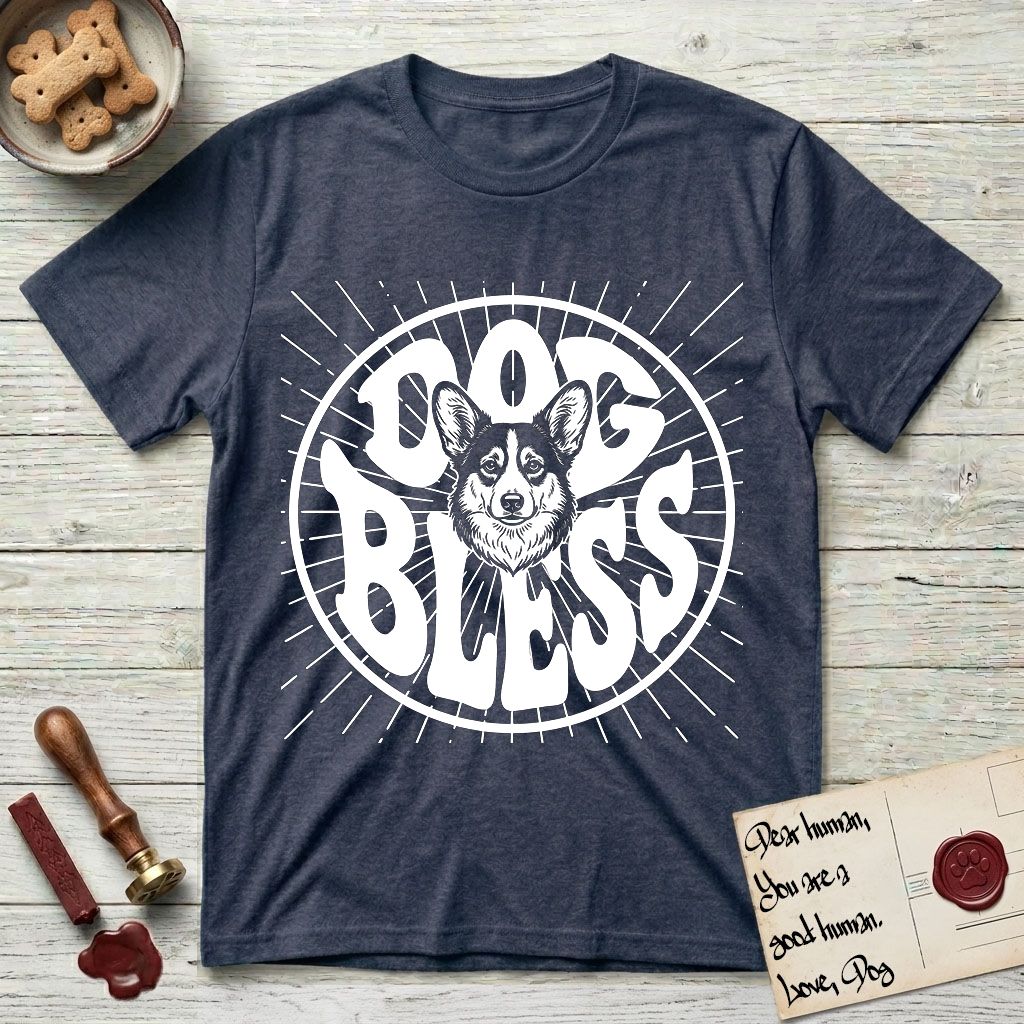 Dog Bless Corgi T-Shirt flat lay in Heather Navy, featuring Retro bubble-letter badge reading DOG BLESS with a smiling Corgi face framed in the letter O, chest fluff spilling below the letter, hand-drawn sunburst rays radiating outward.