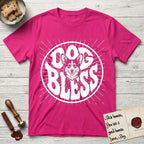 Dog Bless Corgi T-Shirt flat lay in Heliconia, featuring Retro bubble-letter badge reading DOG BLESS with a smiling Corgi face framed in the letter O, chest fluff spilling below the letter, hand-drawn sunburst rays radiating outward.