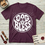 Dog Bless Corgi T-Shirt flat lay in Maroon, featuring Retro bubble-letter badge reading DOG BLESS with a smiling Corgi face framed in the letter O, chest fluff spilling below the letter, hand-drawn sunburst rays radiating outward.