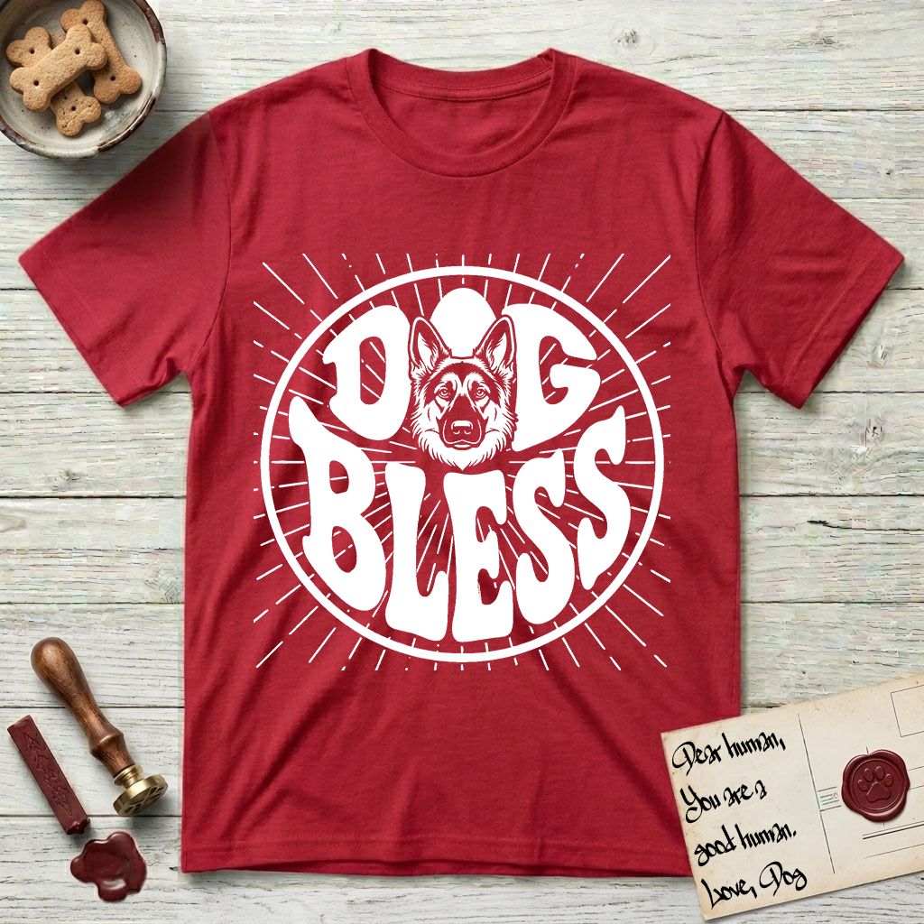 Dog Bless German Shepherd T-Shirt flat lay in Cherry Red, featuring Retro bubble-letter badge reading DOG BLESS with a German Shepherd face with tall upright ears framed in the letter O, hand-drawn sunburst rays radiating outward.