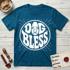 Dog Bless Greyhound T-Shirt flat lay in Antique Sapphire, featuring Retro bubble-letter badge reading DOG BLESS with a slender Greyhound face with folded rose ears framed in the letter O, hand-drawn sunburst rays radiating outward.