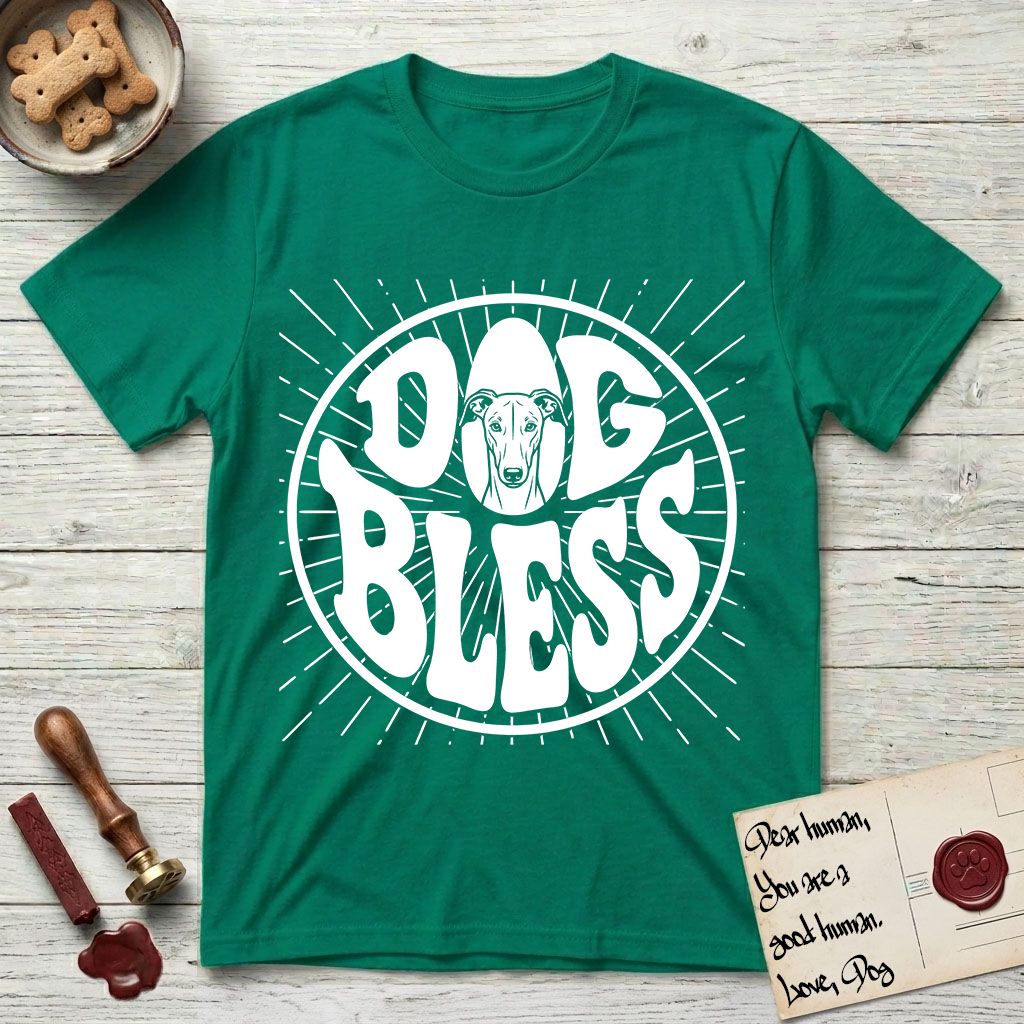 Dog Bless Greyhound T-Shirt flat lay in Kelly Green, featuring Retro bubble-letter badge reading DOG BLESS with a slender Greyhound face with folded rose ears framed in the letter O, hand-drawn sunburst rays radiating outward.