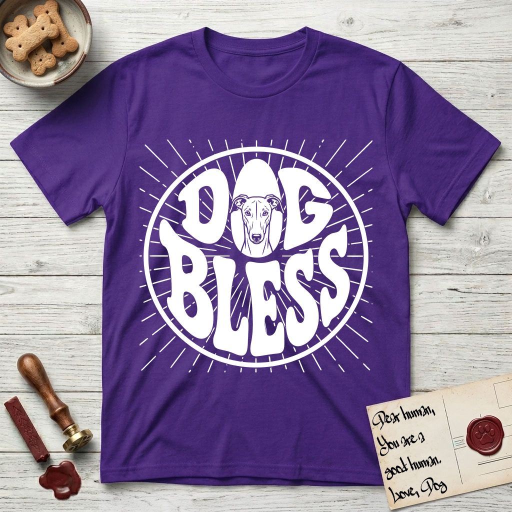Dog Bless Greyhound T-Shirt flat lay in Purple, featuring Retro bubble-letter badge reading DOG BLESS with a slender Greyhound face with folded rose ears framed in the letter O, hand-drawn sunburst rays radiating outward.